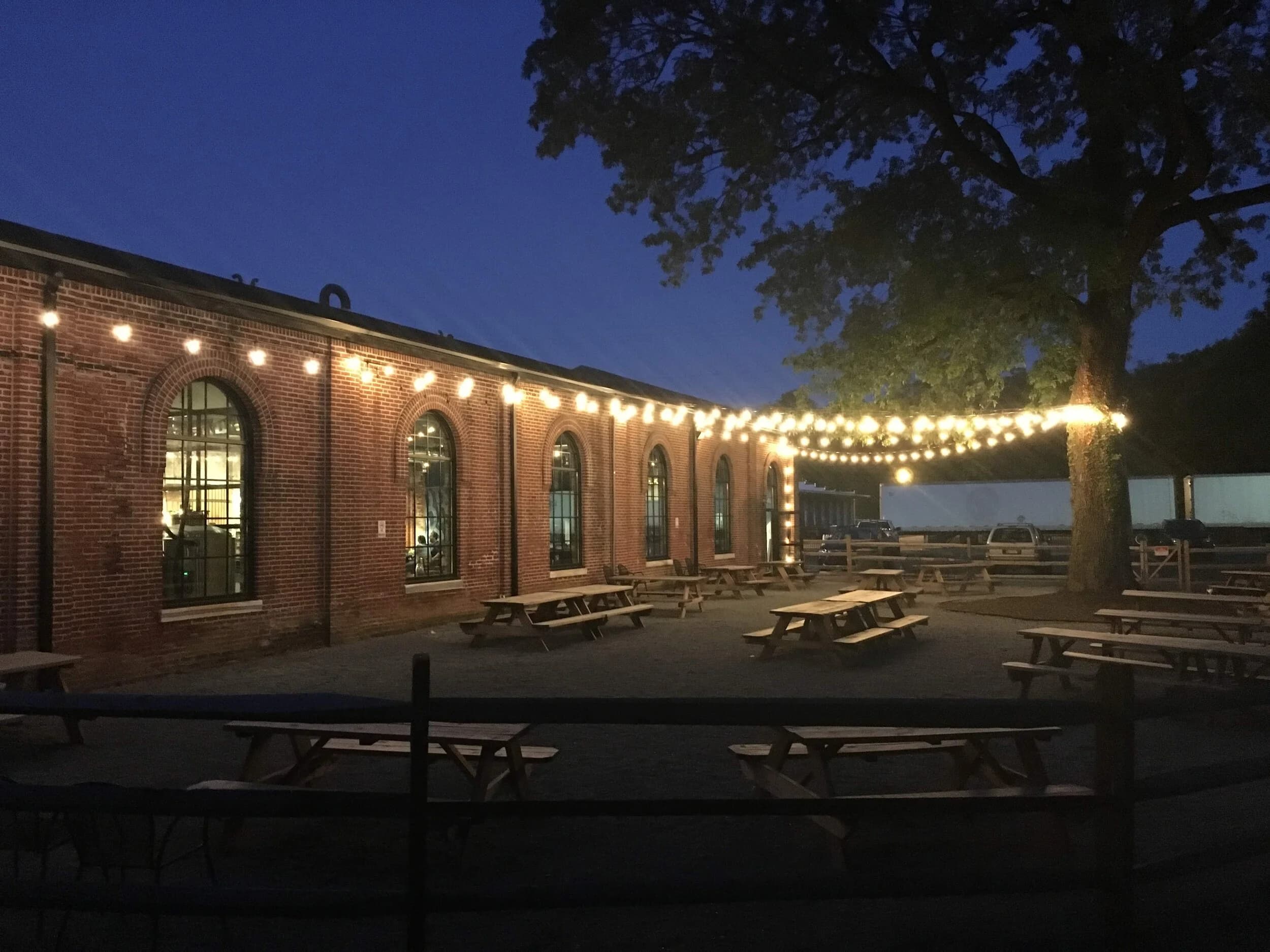 Braeloch's brick beer garden at dusk, strung with warm lights